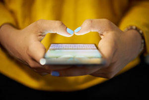 Image of a woman typing on a smartphone