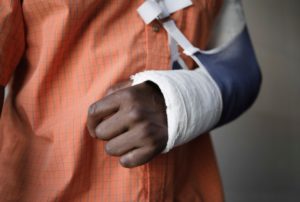 Image of a man with a broken arm in a cast and a sling.