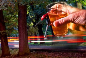 Image of a hand holding an alcoholic drink and car keys